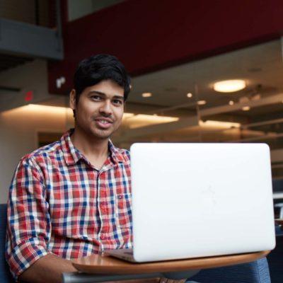 Male international student studies at his laptop